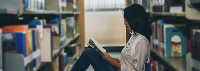 woman sitting on the floor of a library