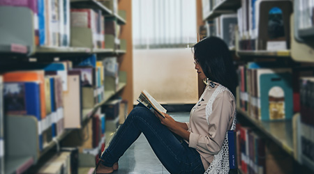 woman sitting on the floor of a library